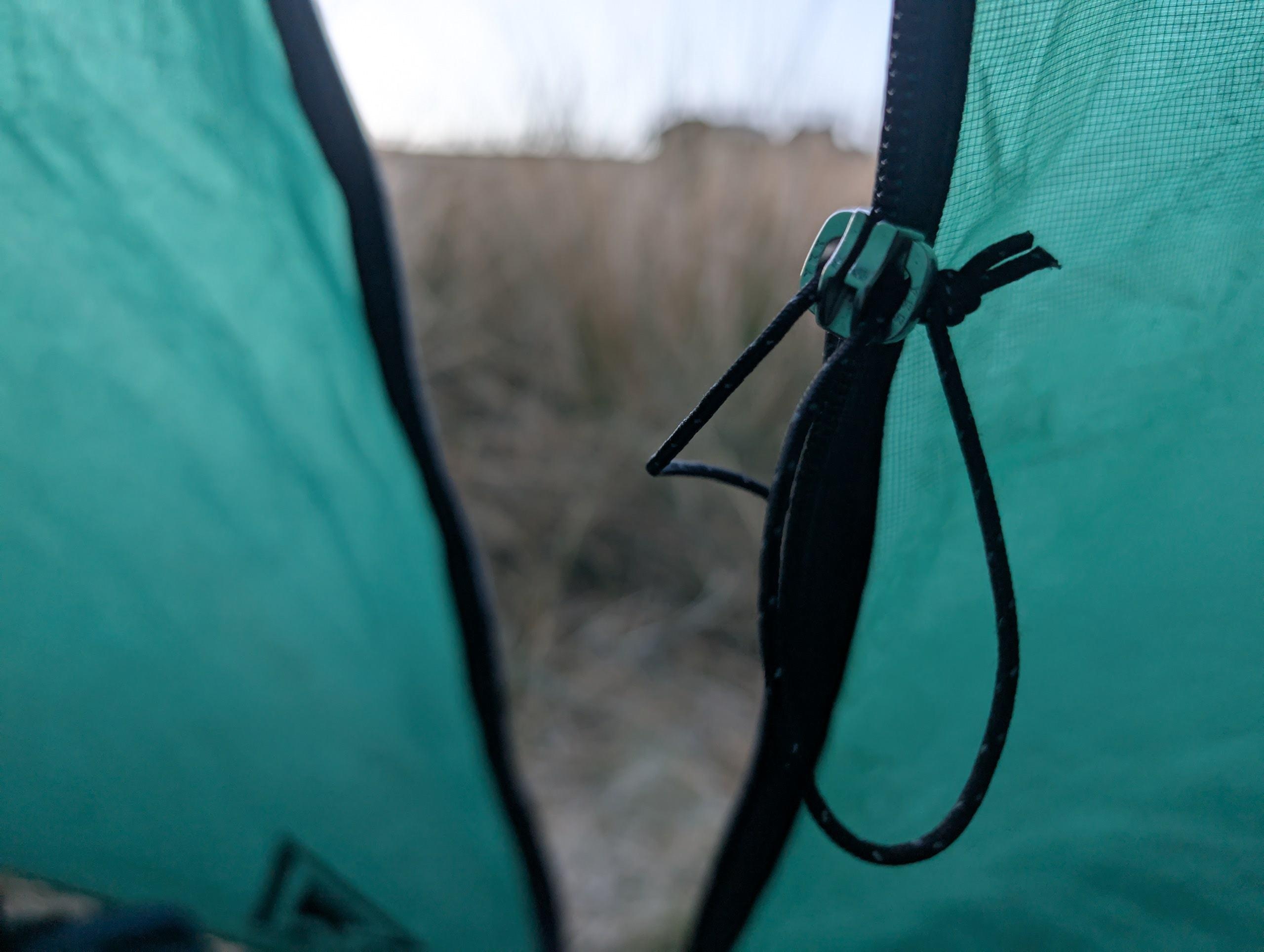 Replacing a worn slider on a tent zipper with pliers, showing how to fix a tent zipper