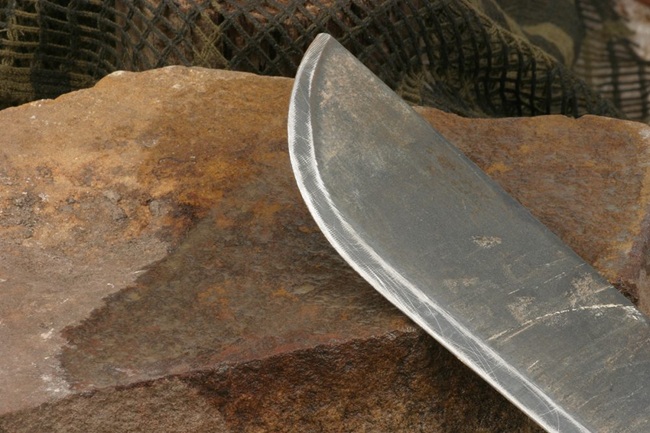 shapening a knife on a rock